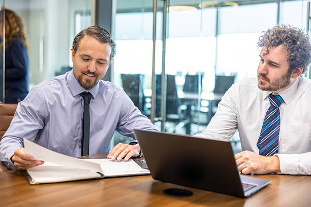 istock Businessmen collaborating at desk 2218664851