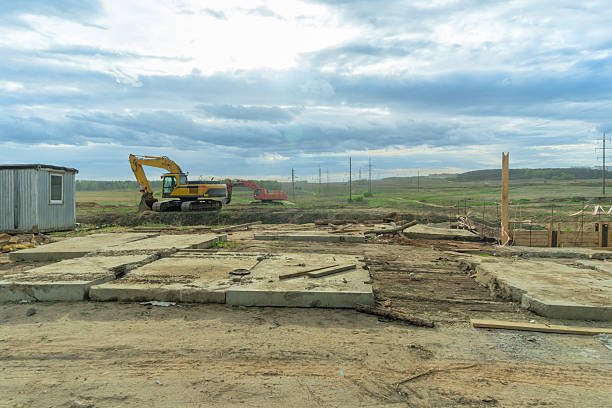 Dynamic Construction Site: Heavy Machinery in Action Under a Dramatic Sky. Innovative Infrastructure Development: Excavators and Bulldozers Transforming the Landscape.