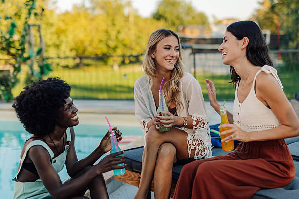 istock Three young women having fun at the poolside 2218669356