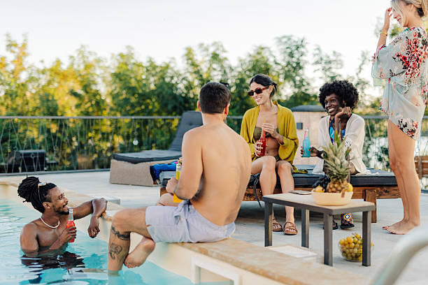istock Friends enjoying drinks and conversation by the poolside during summer vacation 2218669362