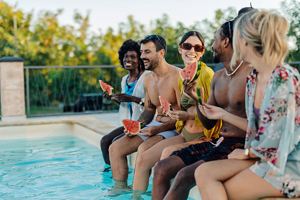 istock Friends enjoying watermelon by the pool during summer vacation 2218669365