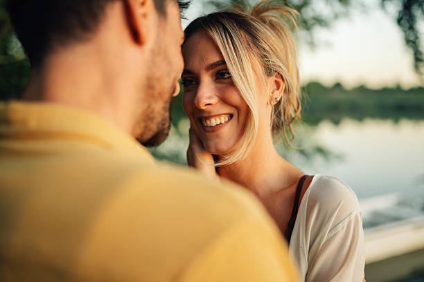 istock Young couple sharing a romantic moment by the lake 2218669968