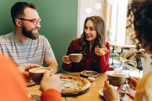 istock Friends enjoying pizza and coffee, talking and having fun at a cafe 2218670167