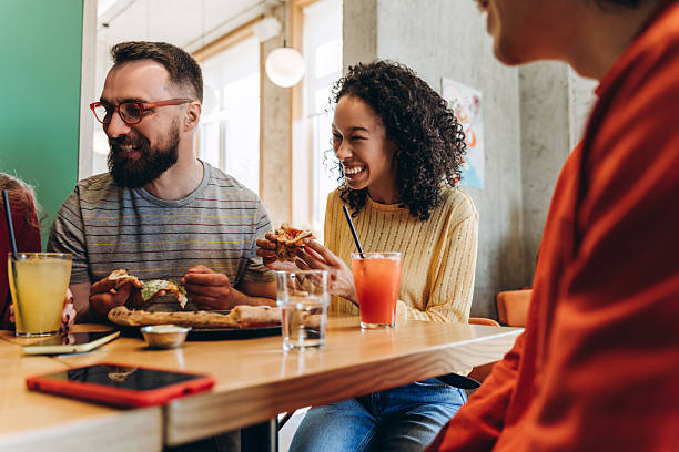 istock Cheerful friends eating pizza and drinking juice in restaurant 2218670176
