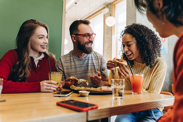 istock Cheerful friends eating pizza and drinking juice in restaurant 2218670180