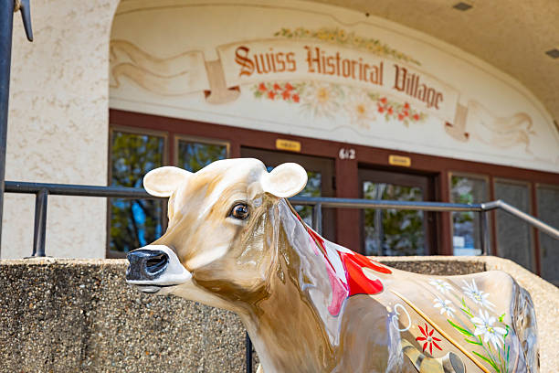 San Gottardo, Switzerland  - September 15, 2024: A vibrant red and white cow statue stands proudly at San Gottardo, showcasing local culture against stunning mountain views.