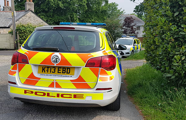 Two liveried police cars from Devon and Cornwall Police parked at the side of the road attending a call.