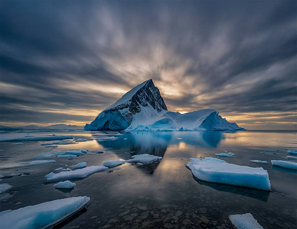 Majestic lonely iceberg floating in calm Arctic waters under a moody sky. Minimalist seascape capturing the raw beauty and isolation of nature. Ideal for climate, nature, and travel theme