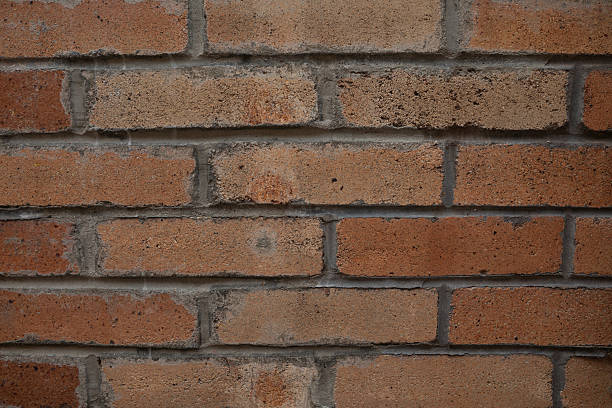 Weathered red and brown brick wall with gray mortar lines, ideal for use in backgrounds, design textures, renovation themes, or building-related creative projects and digital assets.