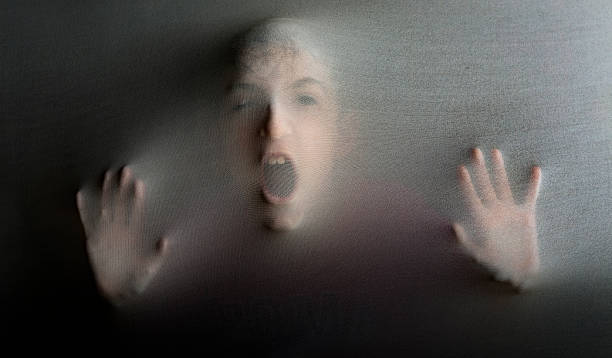 istock Person screaming in spooky situation behind fabric representing mental illness 2218673267