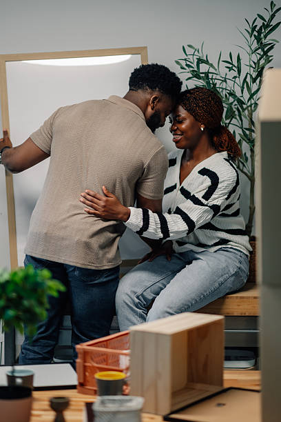 istock Young couple hanging a picture frame in new home 2218674344