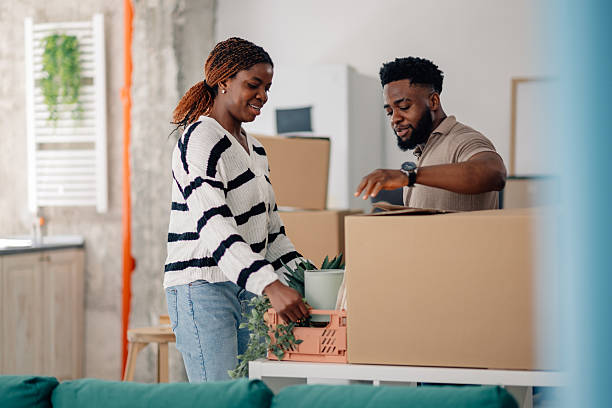 istock Happy couple unpacking boxes in new home after moving 2218674362