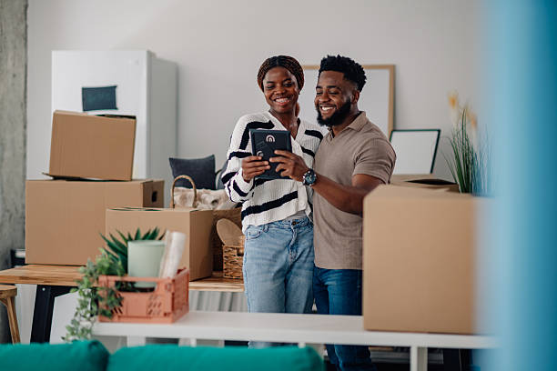 istock Happy couple looking at photo in new home while unpacking boxes 2218674382