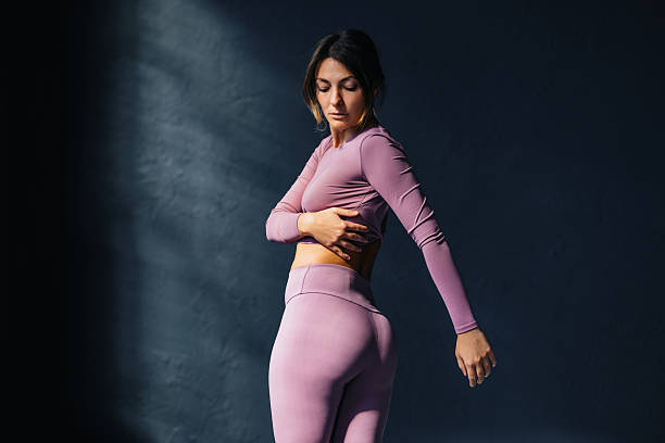 istock Woman in Activewear Stretching in Studio Light Outline 2218675384