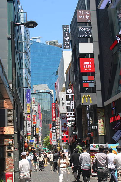 Seoul, South Korea-June 4, 2025: People walking by a colorful array of shops, cafes, bars, and restaurants in downtown Myeongdong, Seoul