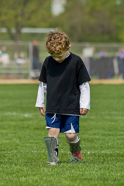 istock Front view of sad young boy soccer player after game with head down. 2218678971