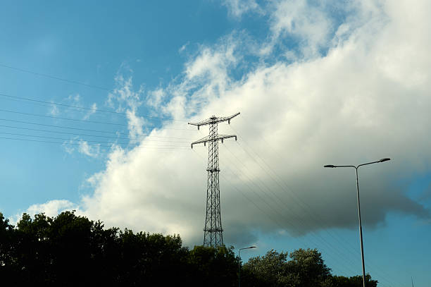 Metal electricity pylon with power lines passing overhead on a cloudy day