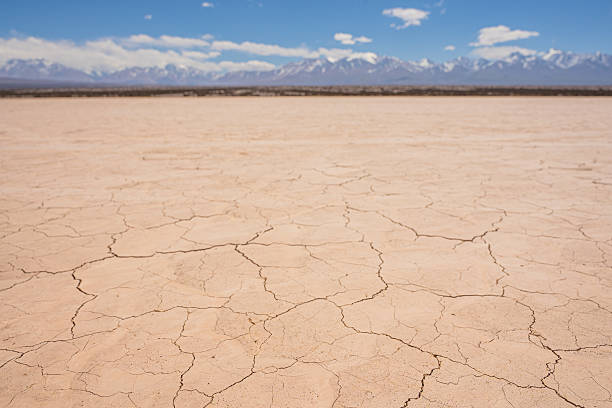 Cracked deserted land with mountains and the sky behind