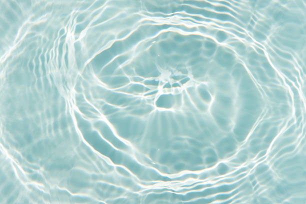 istock Blue water with ripples on the surface. Defocus blurred transparent blue colored clear calm water surface texture with splashes and bubbles. Water waves with shining pattern texture background. 2218680516