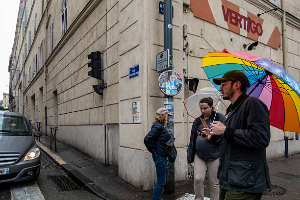 Street rear view of  pedestrian  in the rain with multi colored  umbrella. Santiago de Compostela, Galicia, Spain.