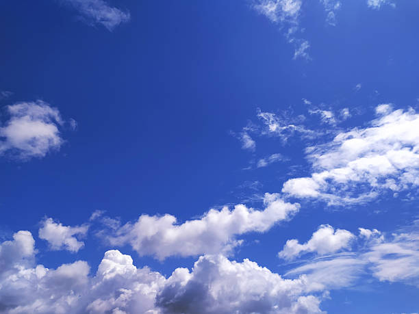 istock Vibrant blue sky filled with fluffy white clouds, perfect for background use. Evokes freedom, peace, and inspiration. Ideal for uplifting themes and designs. 2218683491