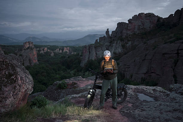 Solo Rider On E-Bike Illuminated By Digital Tablet At Dusk