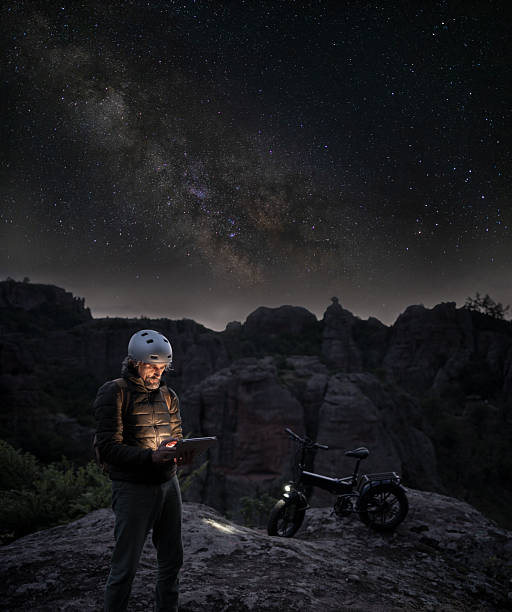 istock Solo Rider On E-Bike Illuminated By Digital Tablet Under Starry Sky 2218683693
