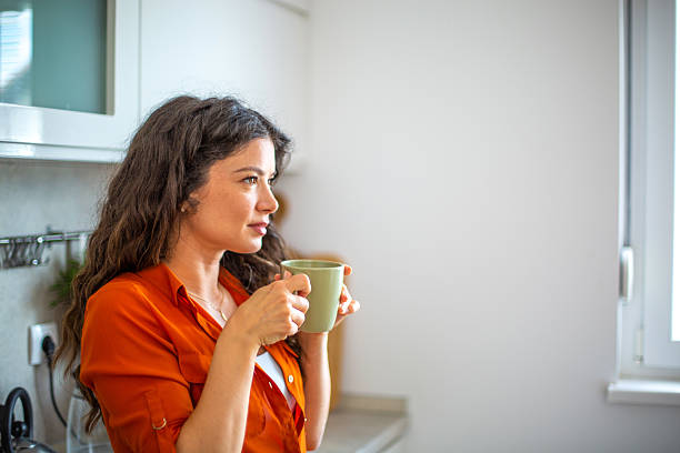 istock Woman enjoying a cup of coffee in her kitchen 2218684736