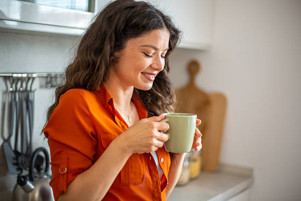istock Young woman enjoying a cup of coffee in her kitchen 2218684792