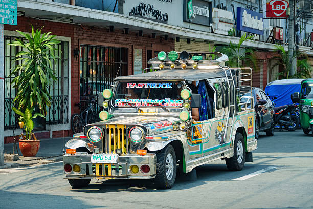 Jeepney transports people in downtown Manila, Philippines on a sunny day.