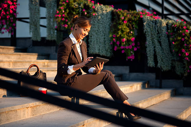 istock Young smiling female entrepreneur using digital tablet in front of her office building 2218691638