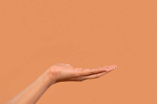 istock Open hand gesture against a warm orange background inviting offers and sharing with a calm and welcoming demeanor 2218696965