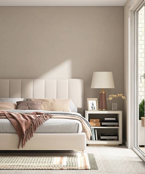 istock Modern cream colored bed with bedside table, lamp in minimal, cozy bedroom in sunlight from sliding door for luxury interior design decoration, product display background 3D 2218698302