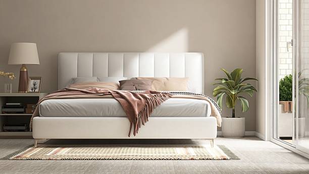istock Modern cream colored bed with bedside table, lamp in minimal, cozy bedroom in sunlight from sliding door for luxury interior design decoration, product display background 3D 2218698303