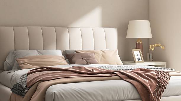 istock Modern cream colored bed with bedside table, lamp in minimal, cozy bedroom in sunlight from sliding door for luxury interior design decoration, product display background 3D 2218698398
