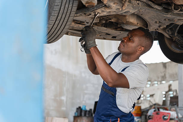 istock Auto Mechanic Working on Undercarriage with Wrench, Professional Technician Servicing Car on Lift, Focused Repairman Fixing Vehicle Suspension 2218699108