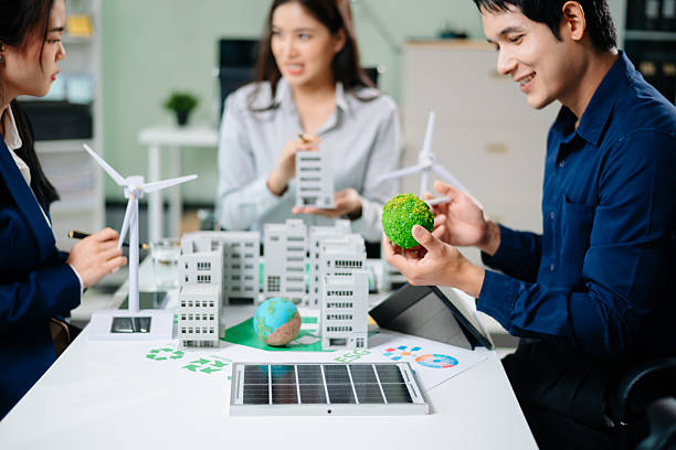 istock Professionals for a greener future. Showcasing renewable energy solutions with solar panels, wind turbines, and a model house. 2218701515