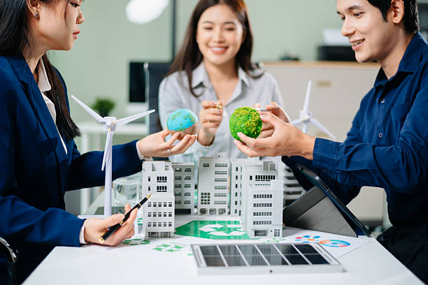 istock Professionals for a greener future. Showcasing renewable energy solutions with solar panels, wind turbines, and a model house. 2218701520