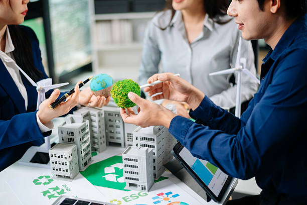 istock Professionals for a greener future. Showcasing renewable energy solutions with solar panels, wind turbines, and a model house. 2218701533