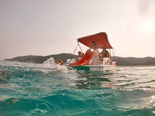 Photo of a children jumping in the sea from a speedboat.