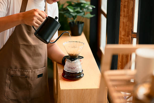 istock Man pouring hot water into coffee dripper to brew fresh pour over coffee 2218704863