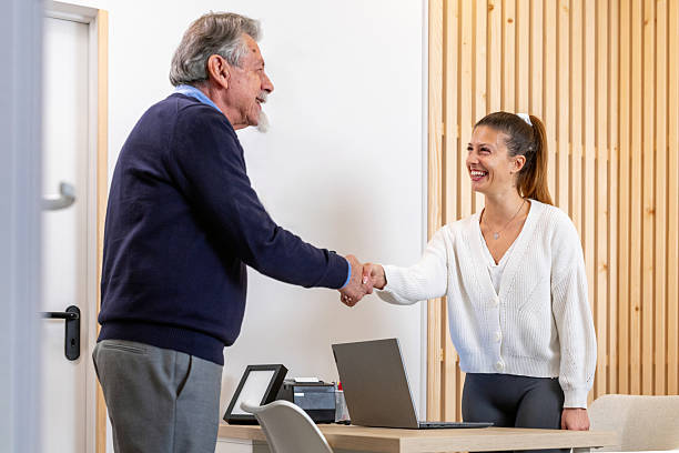 istock Senior Client And Receptionist Share Professional Handshake At Modern Office Reception Desk 2218706379