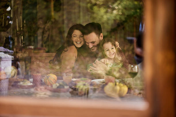 istock Happy parents enjoying with their daughter at dining table. 2218709740