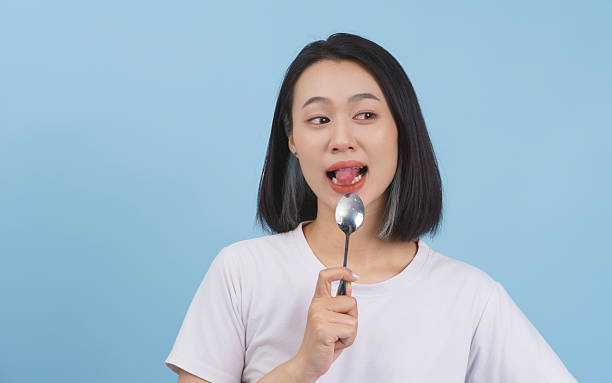 istock Young Woman Enjoying a Spoonful Against a Light Blue Background 2218710221