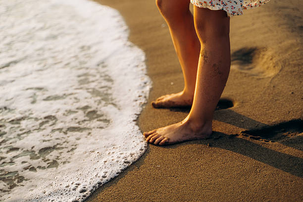 Barefoot on Sand as Ocean Waves Approach