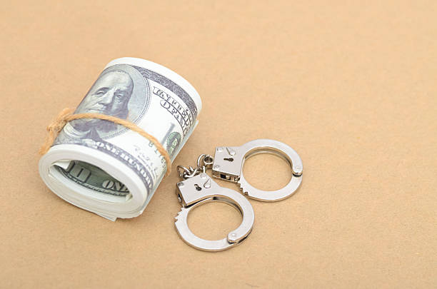 istock Bribery and Corruption Concept with Money Bundle and Open Handcuffs Ready for Arrest 2218716150
