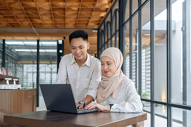 istock Two professionals working together using a laptop in a modern space, depicting collaboration, teamwork, and professional growth. The background features a stylish office interior. 2218721161