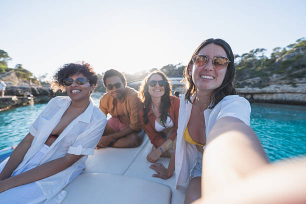 Group of friends enjoying a boat day together, capturing happy moments. Summer, vacation, boat concept