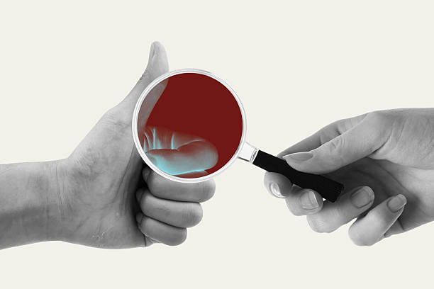 Hand scanning thumbs up gesture using magnifying glass with x-ray vision