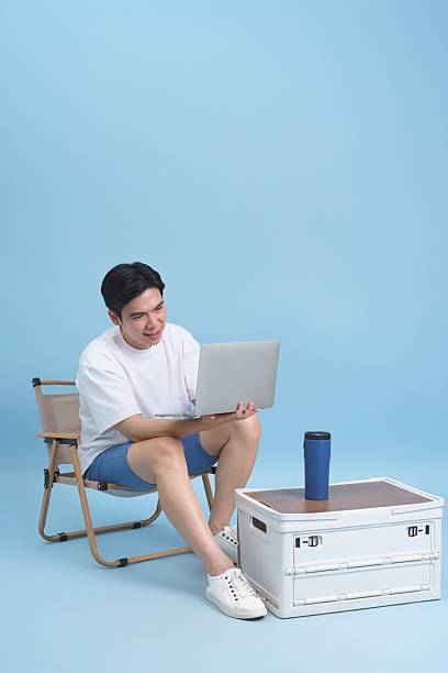istock Young Man Using Laptop and Smiling in a Relaxed Outdoor Setup 2218726362